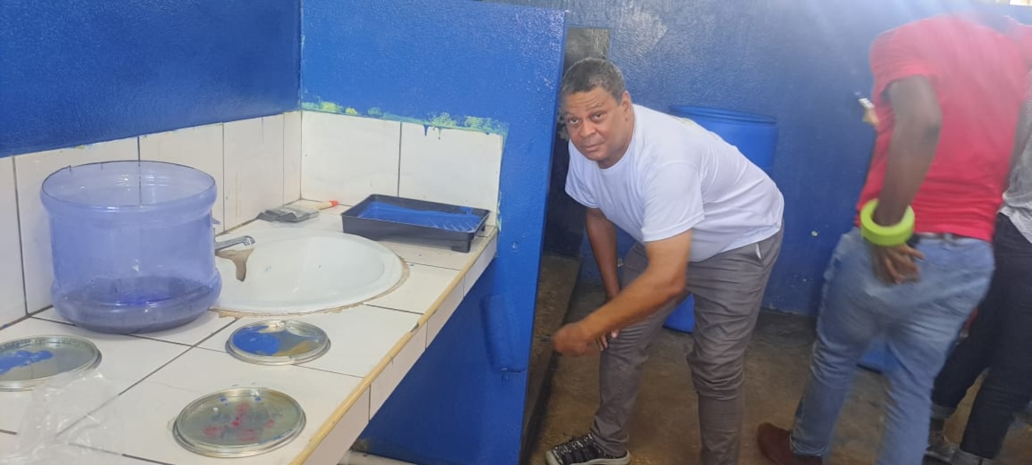 Robert Scott General Manager Lifespan paints the bathroom at the Buff Bay Primary school Lifespan Refreshes Buff Bay Primary School
