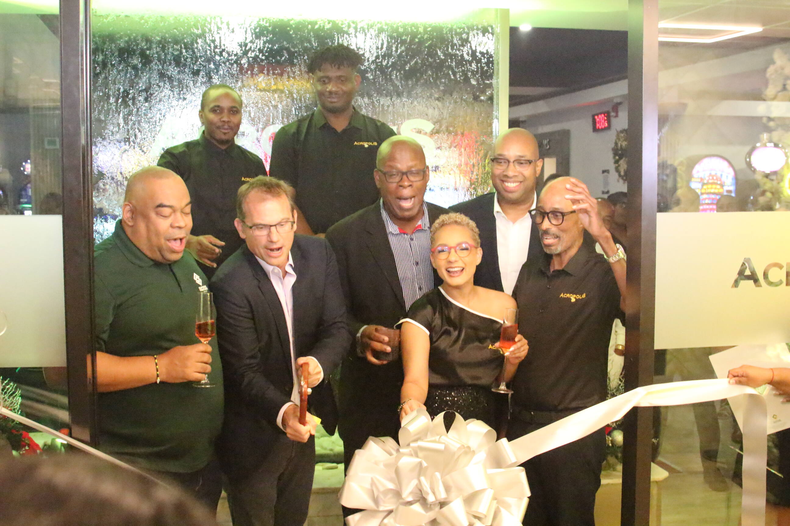 Senior Advisor/Strategist Delano Seivwright (second row, right) joins members of Supreme Ventures Limited in cutting the ribbon during the Acropolis Relaunch on Wednesday Gaming, Cocktails, and Vibes: Acropolis Lounge Relaunch Delivers an Unforgettable Night