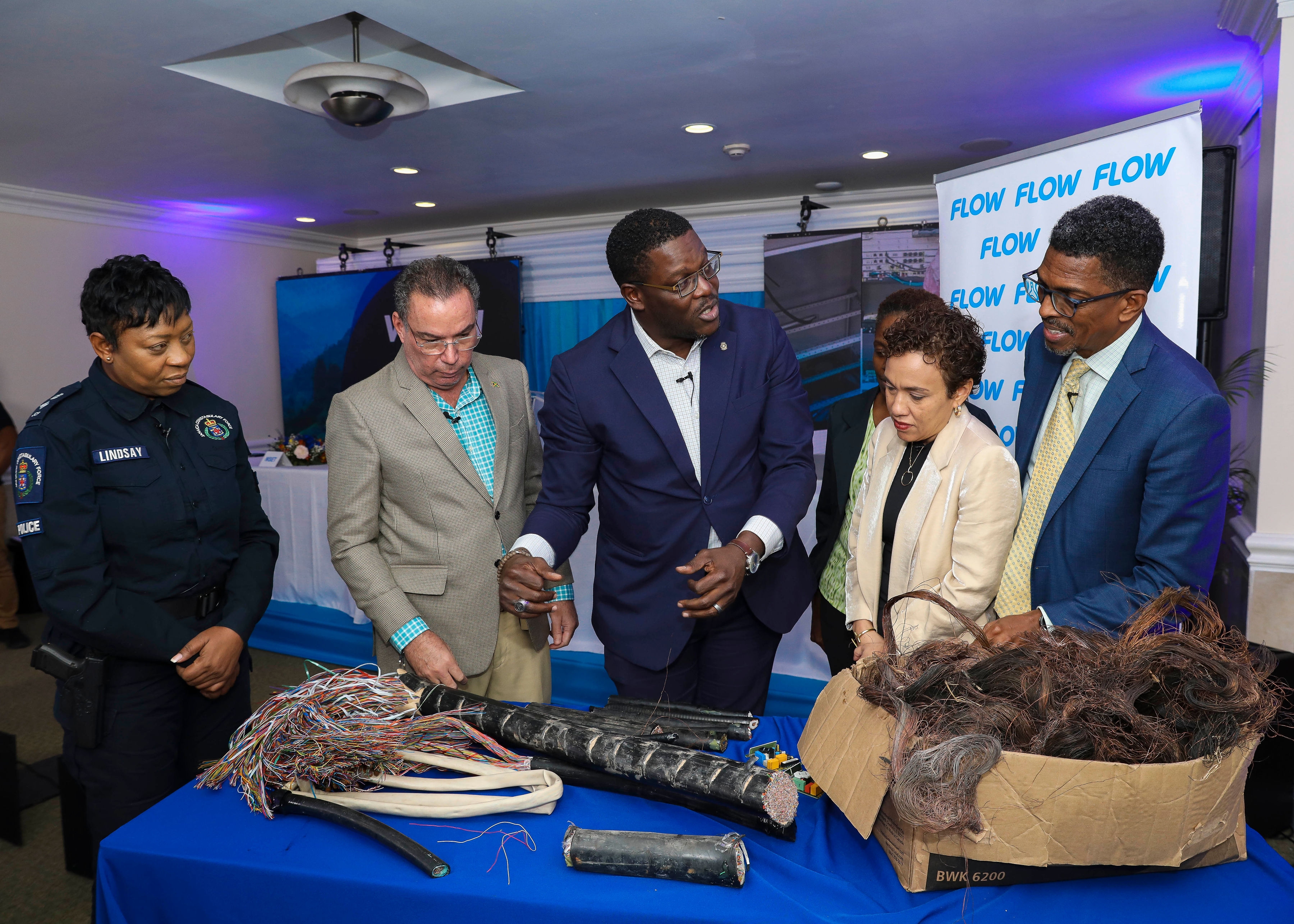 Public and Private stakeholders join Hon. Daryl Vaz, Minister, Science, Energy & Technology and Stephen Price, Vice President and General Manager of Flow Jamaica as they examine some of the cables impacted by theft and vandalism. From left- right are: Head of the JCF’s Corporate Communications Unit (CCU), Senior Superintendent of Police (SSP) Stephanie Lindsay, Mrs. Carolyn Ferguson Arnold, Consumer Advisory Committee on Utilities (CACU), OUR, Mrs. Jacqueline Sharp, Vice President, The Private Sector Organisation of Jamaica (PSOJ) and Mr. Ian Neita, Immediate Past President of the Jamaica Chamber of Commerce (JCC).