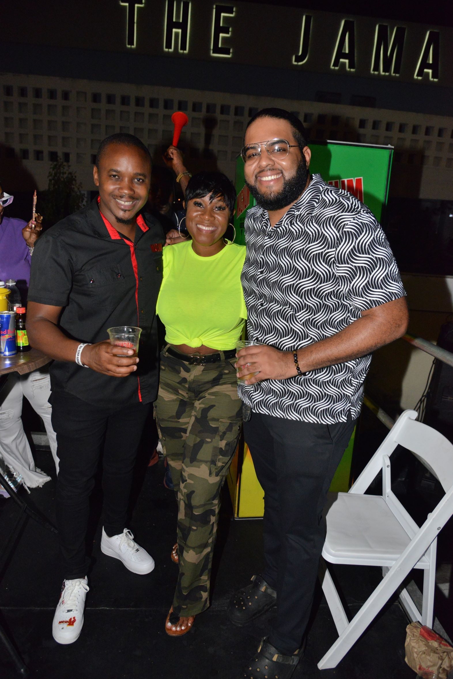 Danielia McLean, Magnum Tonic Wine's Project Manager, is sandwiched by Regional Marketing Manager, Kamal Powell, and Brand PR & Communications Manager, Dominic Bell, on Saturday at the Magnum All-Star Sound Clash Final on Ocean Boulevard.